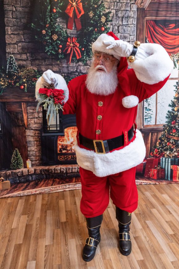 Santa Roger holding a lantern, looking into the distance