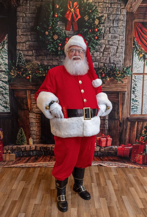 Santa Roger, hands in belt, smiling
